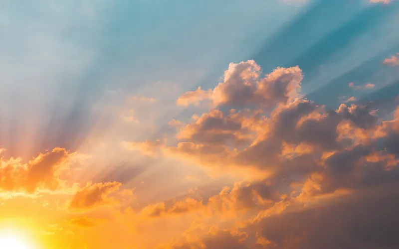 Sun rays breaking through clouds at sunrise