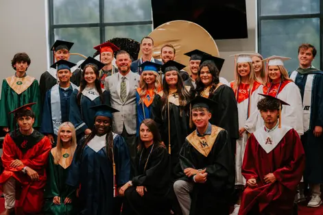 Victory graduates celebrating together in caps and gowns