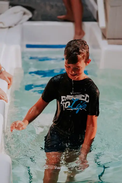 A boy being baptized at Victory