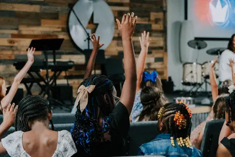Kids raising their hands during worship