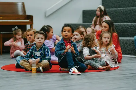 A class of kids seated together with their leaders