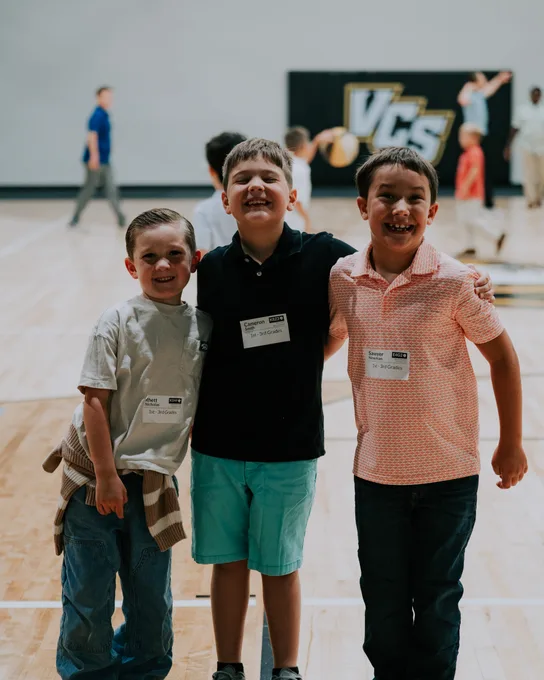 Three boys in name tags standing together outside
