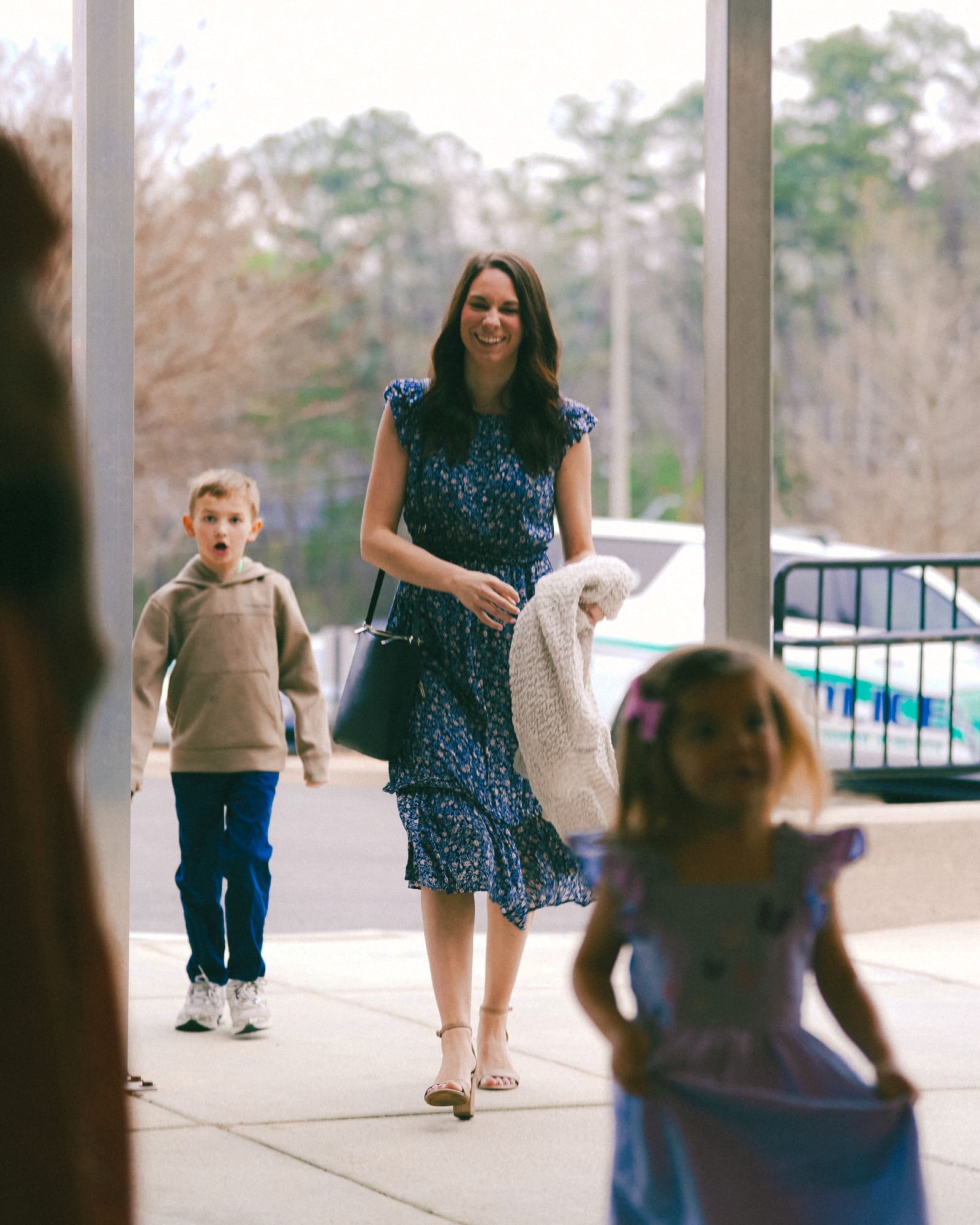 A mom arriving at the entrance with her two kids