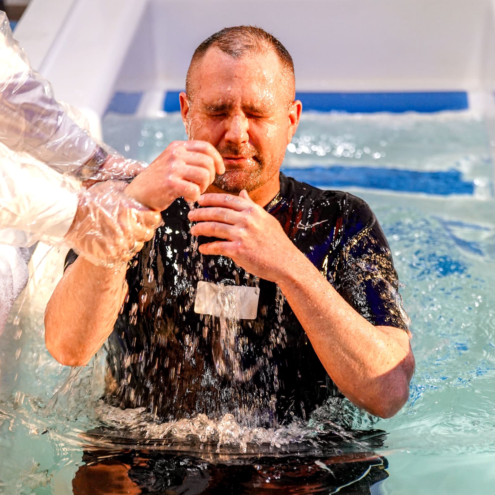 A new believer being baptized by full immersion in the baptistry at Victory Baptist