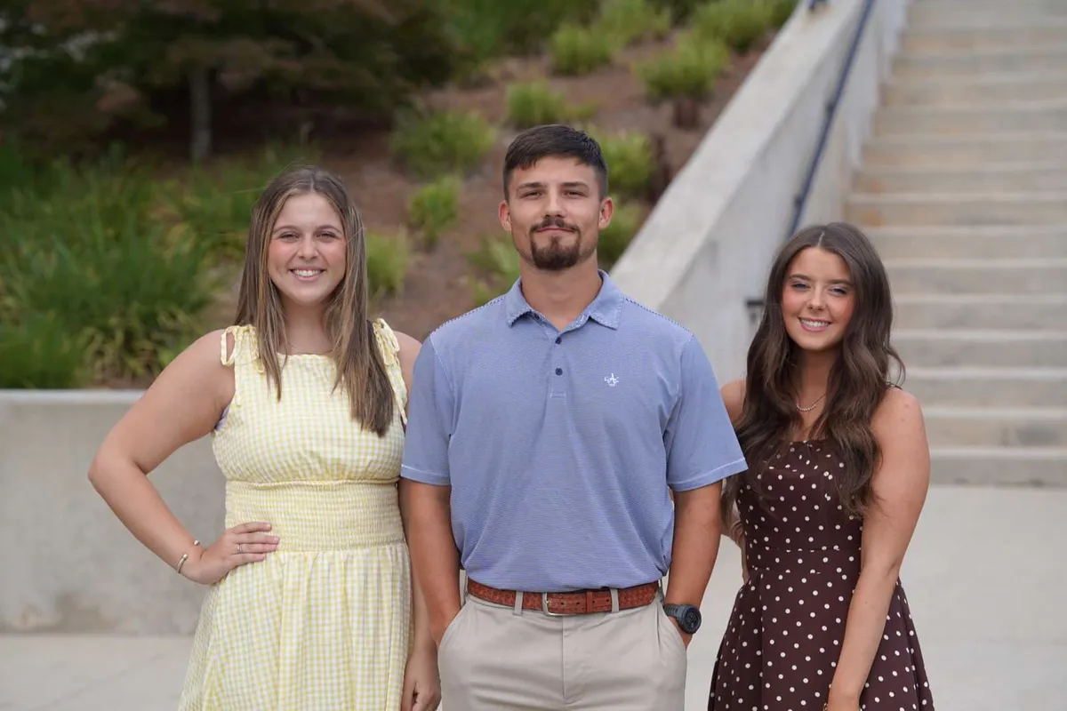 Three Victory Baptist College students standing together outside by the steps