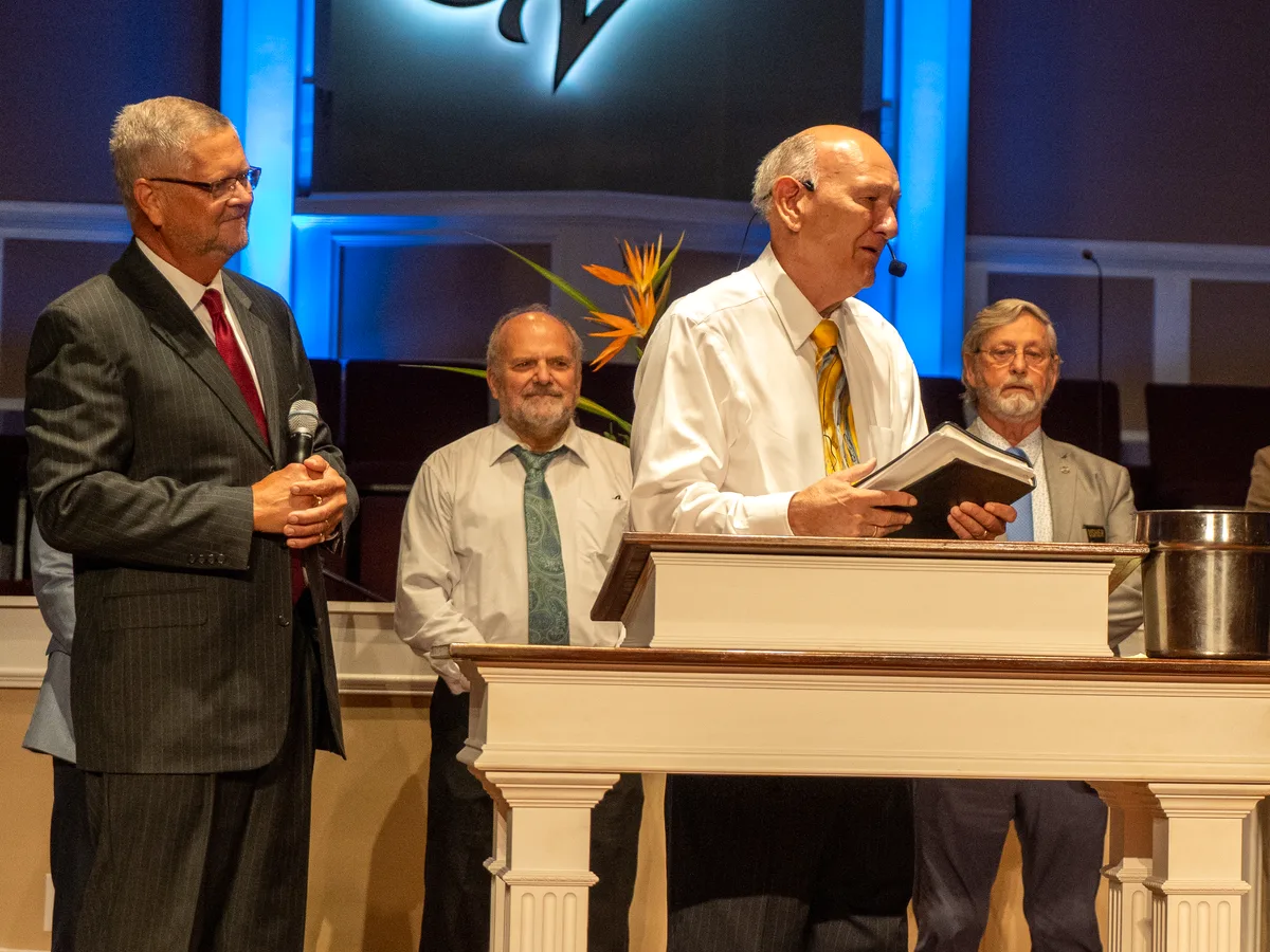 Dr. R. Larry Brown speaking at the pulpit with Pastor CT beside him