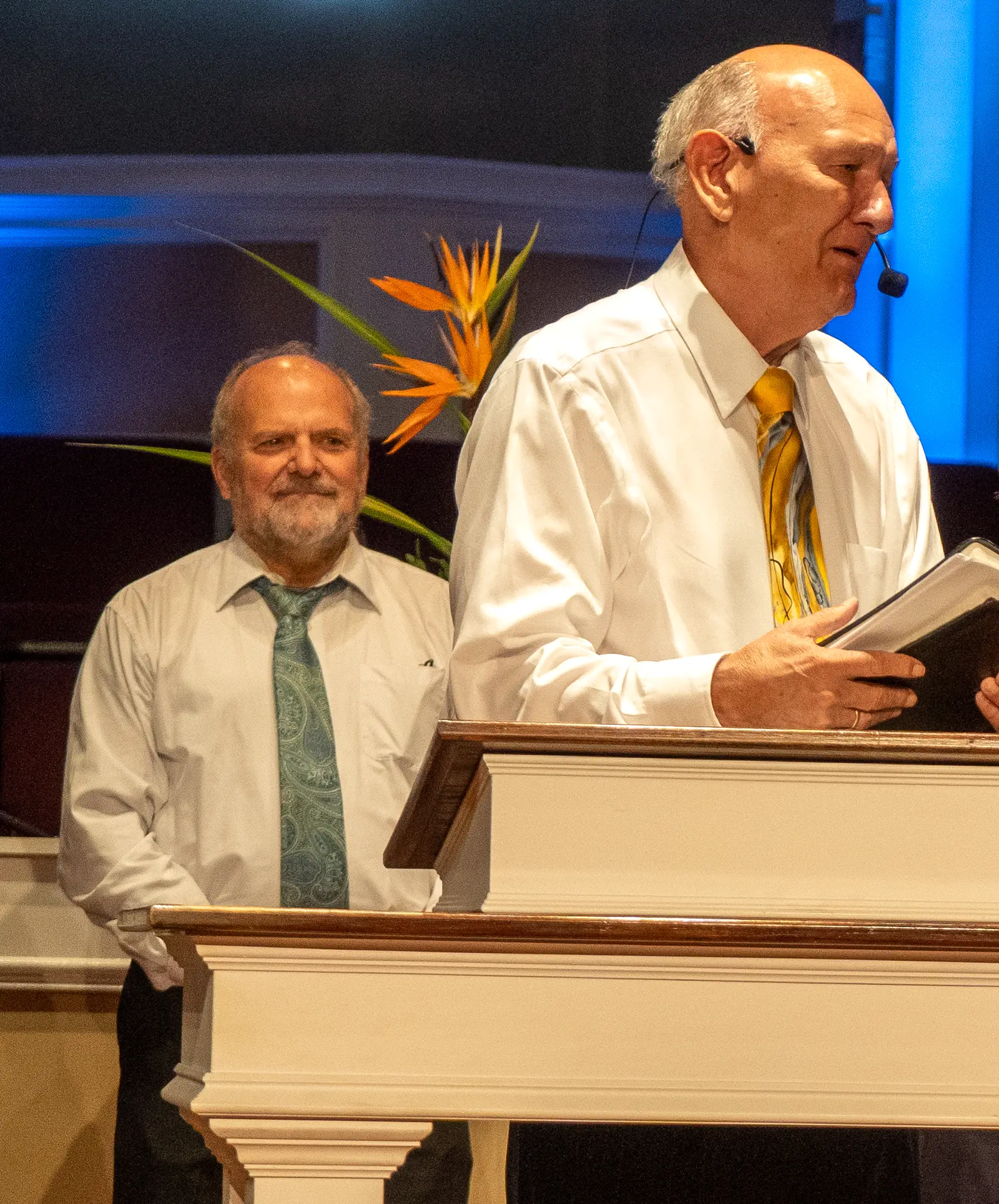 Dr. R. Larry Brown speaking at the pulpit with his Bible open in his hands