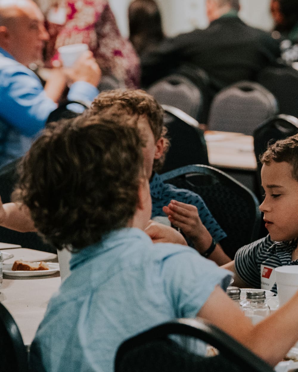 Two kids talking across the table over their meal at a Growth Track class