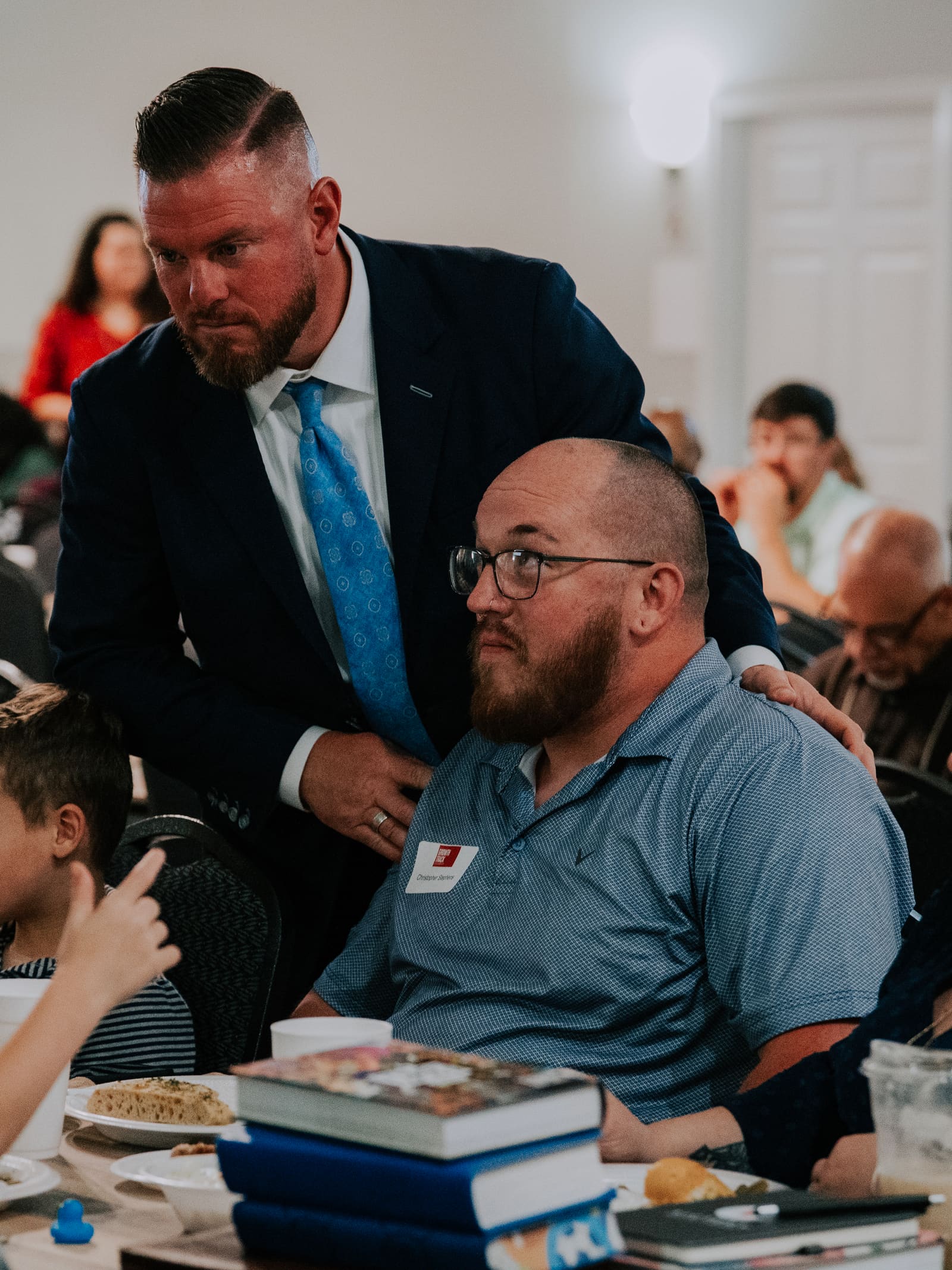 A pastor greeting a family at their table during a Growth Track class