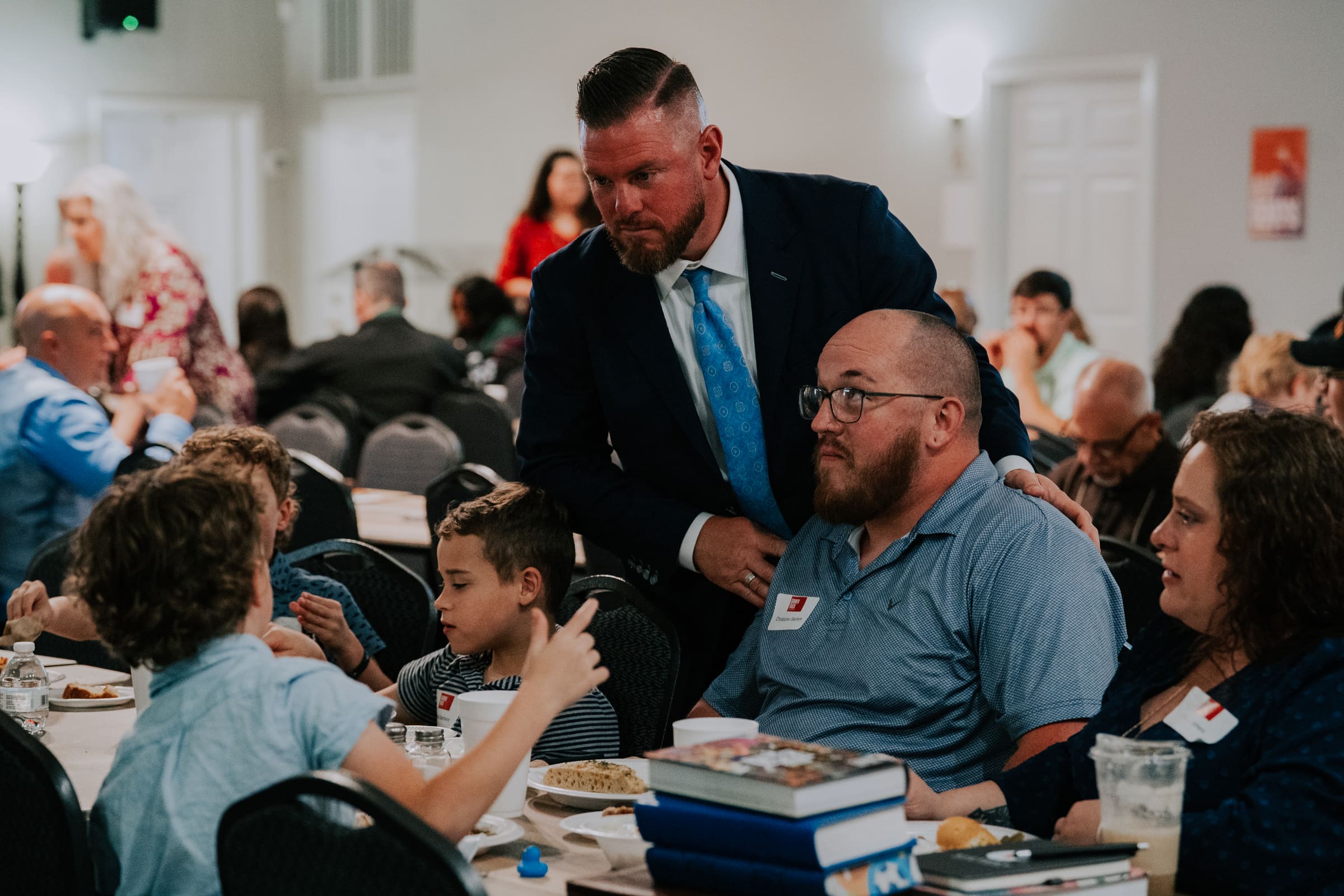 Pastor CT Townsend greeting families at their tables during a Growth Track class in the fellowship hall