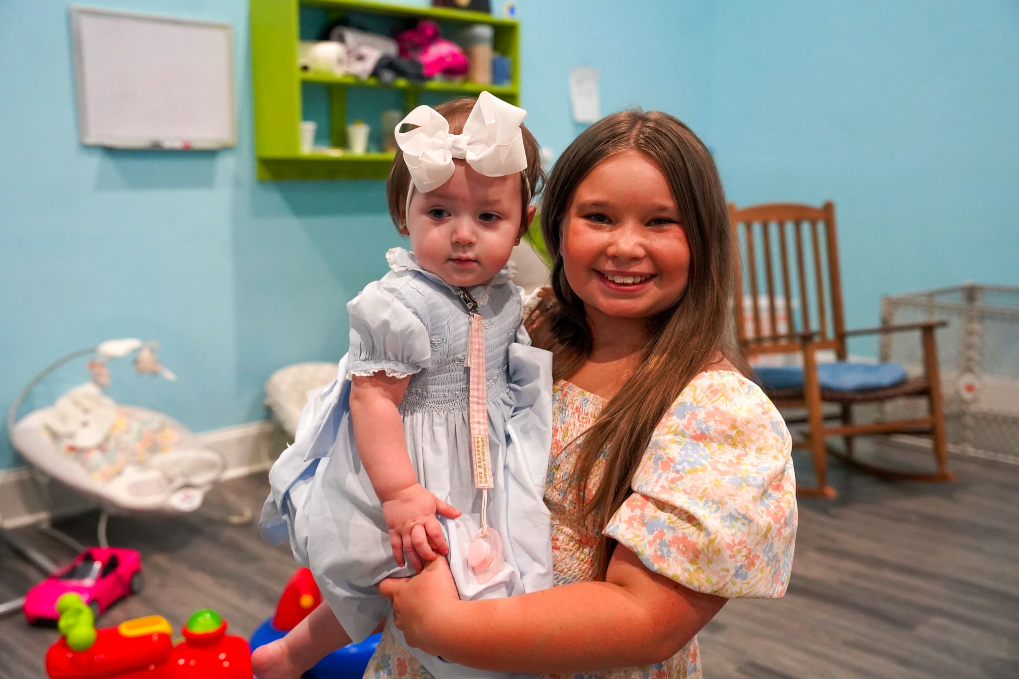 A girl holding a baby in the Victory Nursery