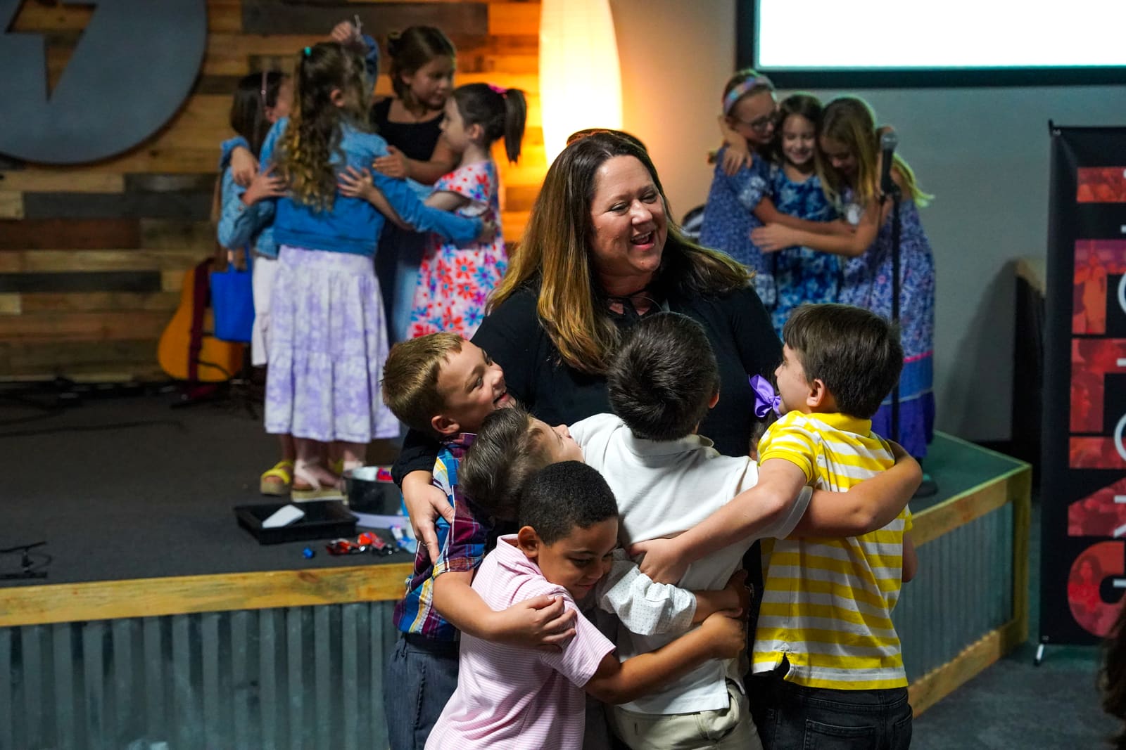 Cheryl Hampton hugging a group of Victory Kids