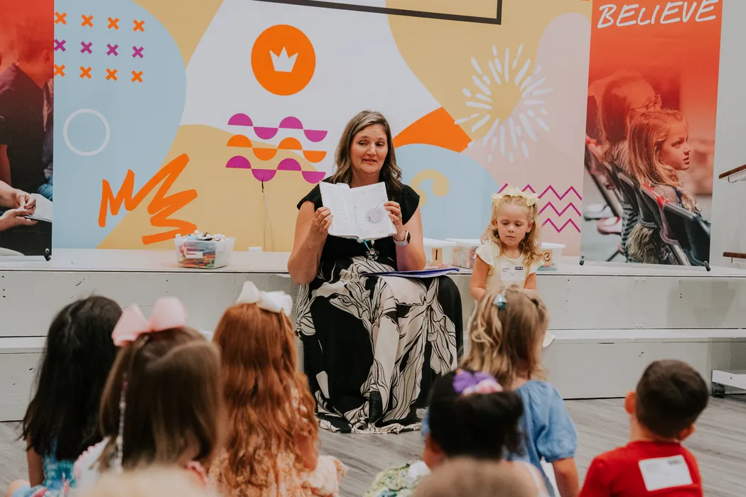 A leader reading to a class of kids in the Victory Kids room