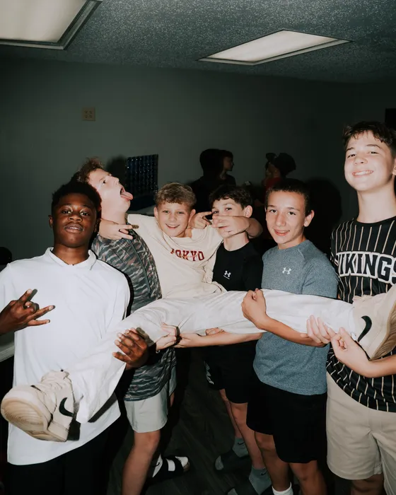 Victory Teens boys carrying a friend across the room