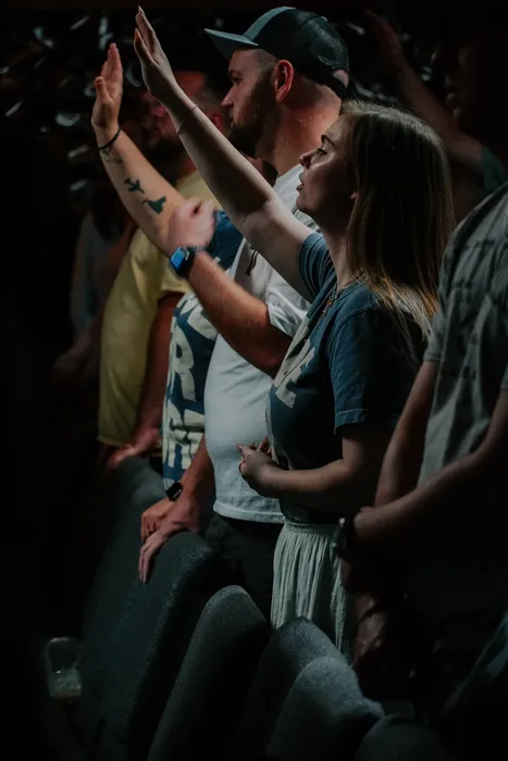 Young adults with their hands raised in worship