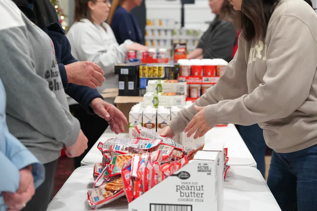 Dream Team members packing food bags along a table